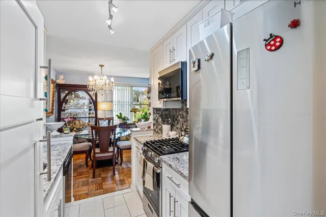 a kitchen with stainless steel appliances kitchen island granite countertop a refrigerator and a stove top oven