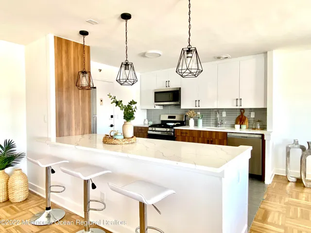 a kitchen with stainless steel appliances granite countertop a sink a stove a refrigerator a microwave oven with a dining table and chairs