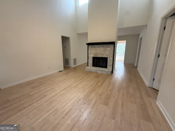 a view of empty room with wooden floor and fireplace