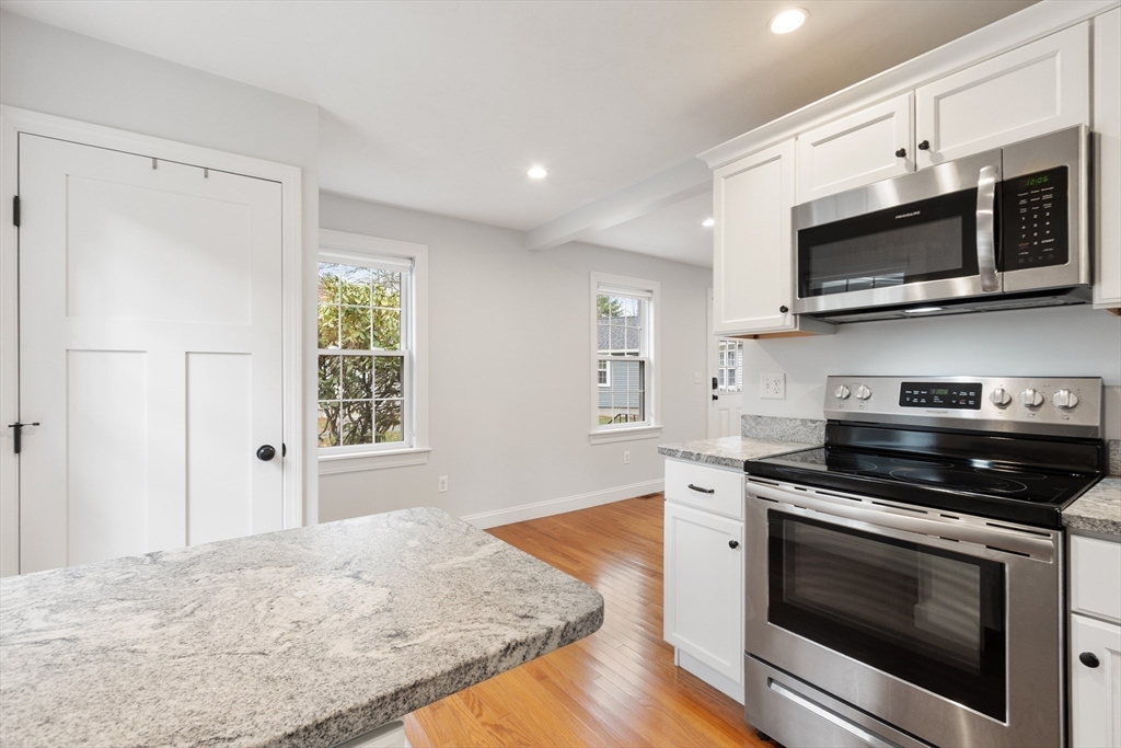 166 Parker Street, Unit 4 Maynard, MA 01754 - Photo 12 of 37 a kitchen with stainless steel appliances a stove microwave and sink