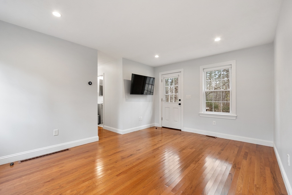 166 Parker Street, Unit 4 Maynard, MA 01754 - Photo 16 of 37 a view of an empty room with wooden floor and a window