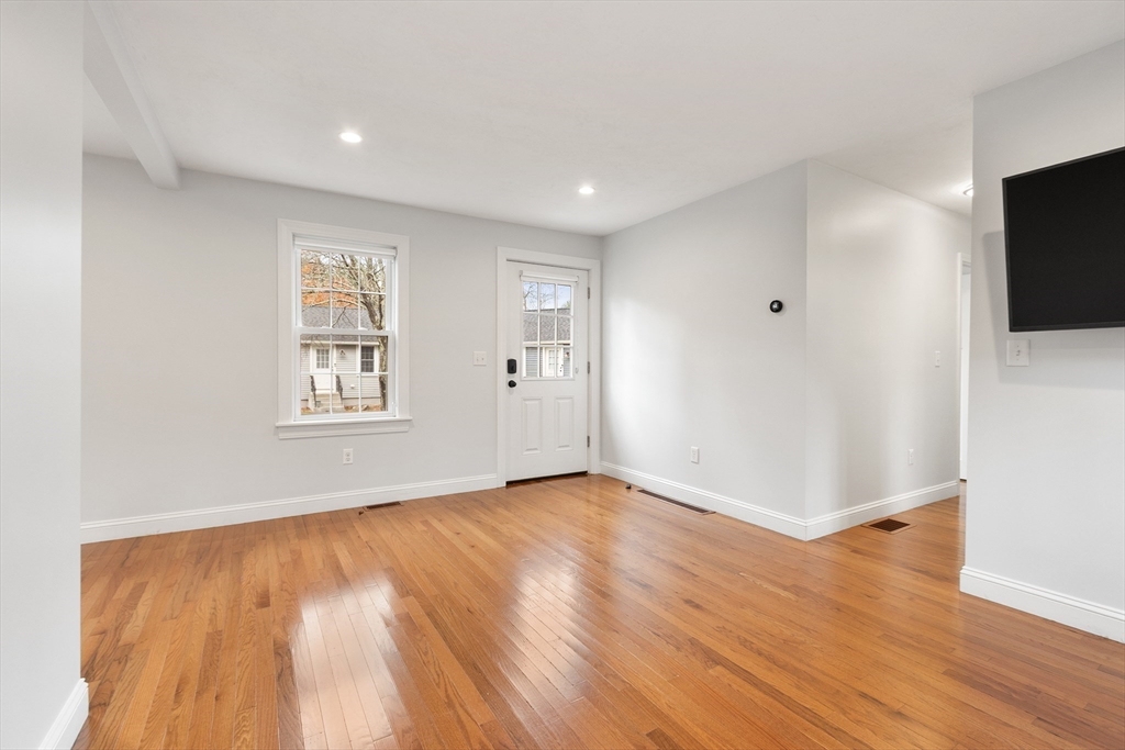 166 Parker Street, Unit 4 Maynard, MA 01754 - Photo 18 of 37 a view of an empty room with wooden floor and a window