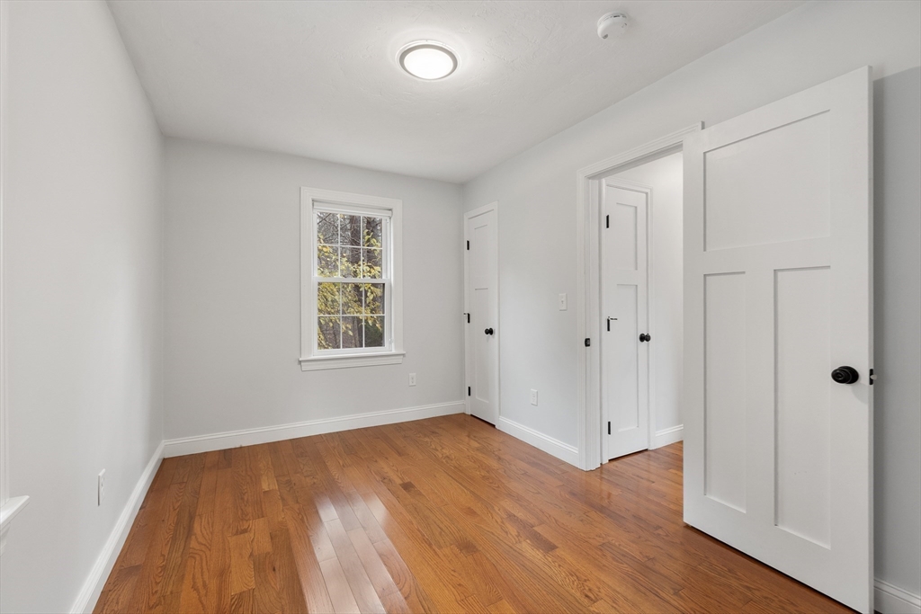 166 Parker Street, Unit 4 Maynard, MA 01754 - Photo 19 of 37 an empty room with wooden floor and windows