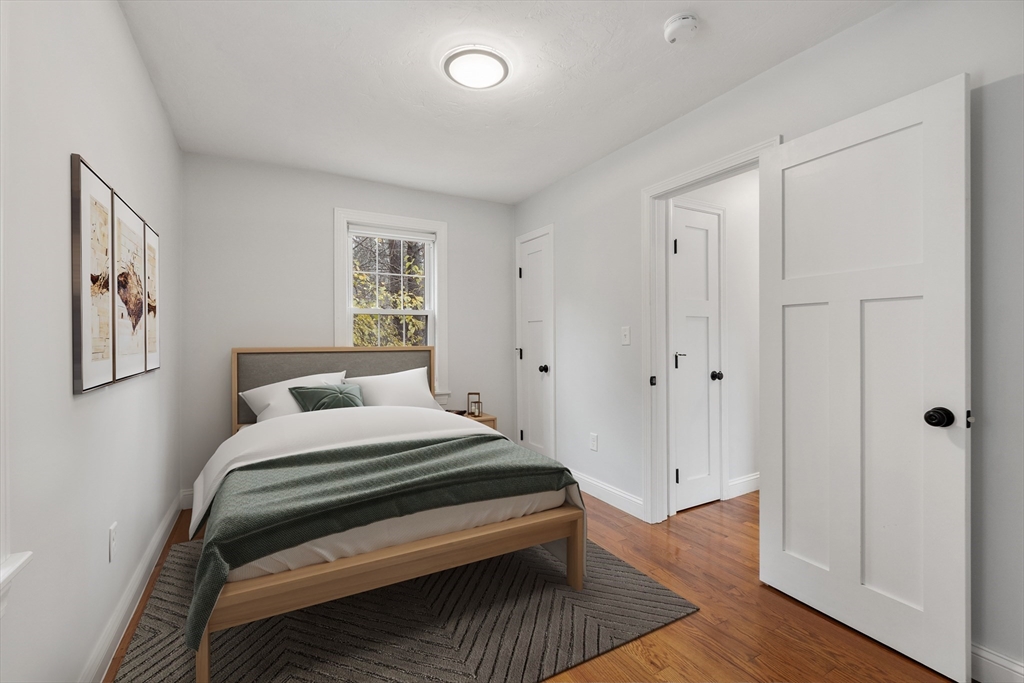 166 Parker Street, Unit 4 Maynard, MA 01754 - Photo 20 of 37 a bedroom with a bed and wooden floor