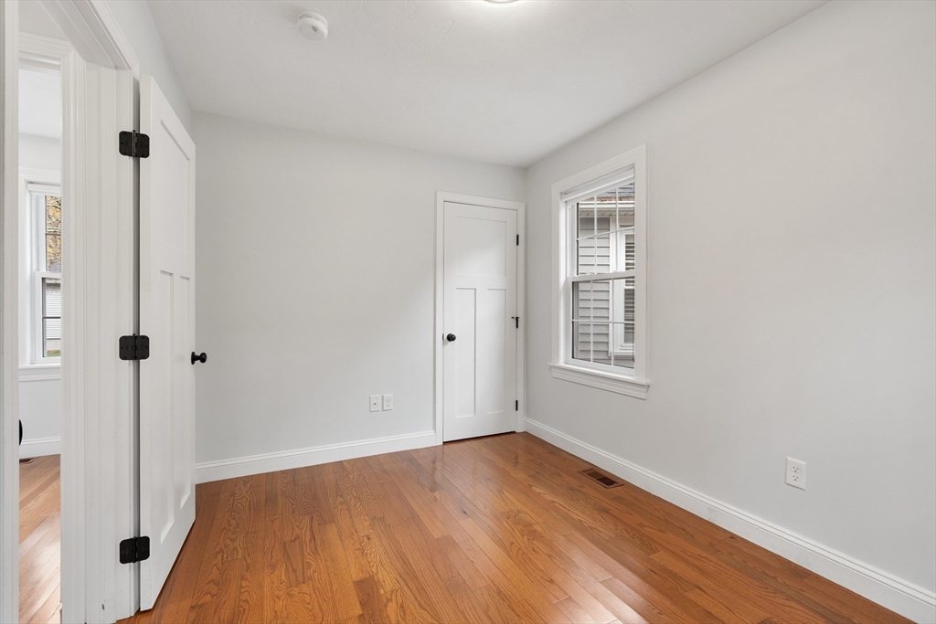 166 Parker Street, Unit 4 Maynard, MA 01754 - Photo 22 of 37 a view of an empty room with wooden floor and a window