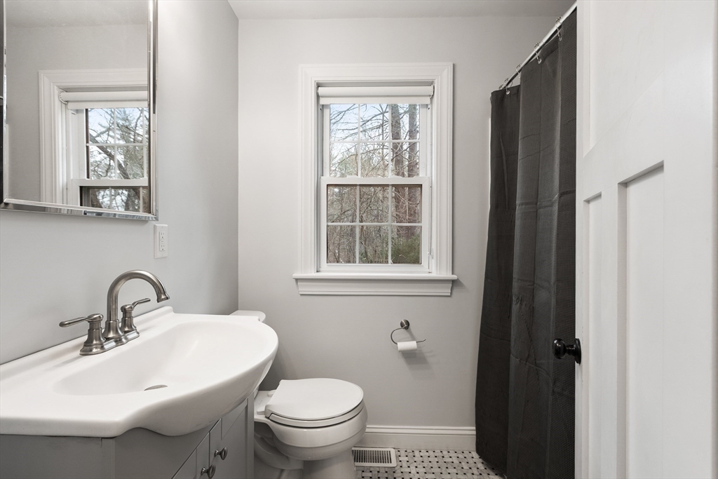 166 Parker Street, Unit 4 Maynard, MA 01754 - Photo 23 of 37 a bathroom with a sink toilet and a mirror