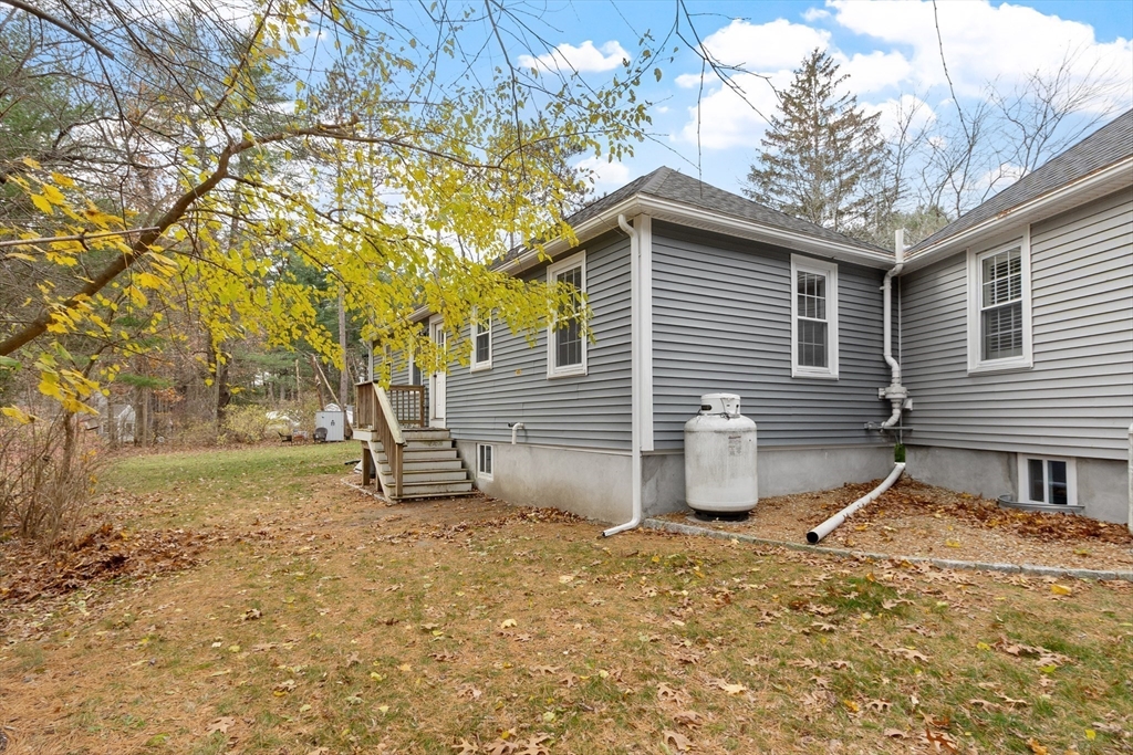 166 Parker Street, Unit 4 Maynard, MA 01754 - Photo 32 of 37 a backyard of a house with barbeque oven and table and chairs