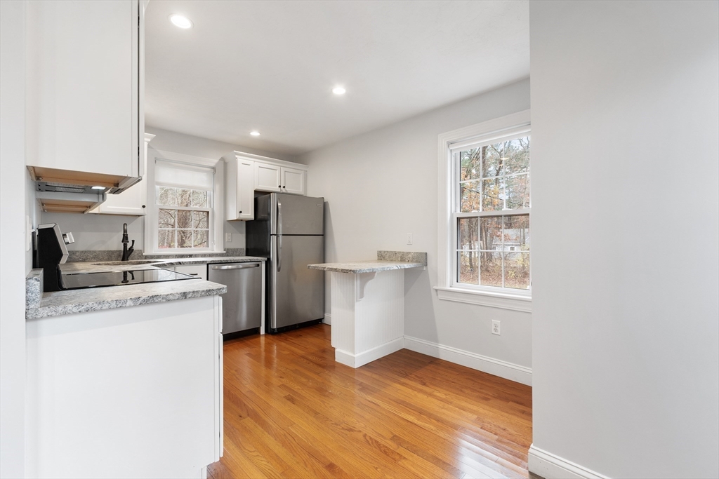 166 Parker Street, Unit 4 Maynard, MA 01754 - Photo 7 of 37 a kitchen with refrigerator and cabinets