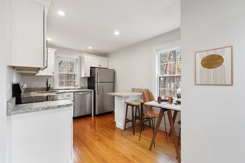 166 Parker Street, Unit 4 Maynard, MA 01754 - Photo 8 of 37 a kitchen with refrigerator and chairs