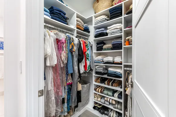 a view of walk in closet with clothes and shoes