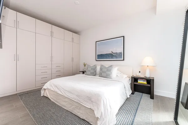 a bedroom with a bed and a painting on the wall