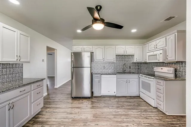 a kitchen with white cabinets and stainless steel appliances