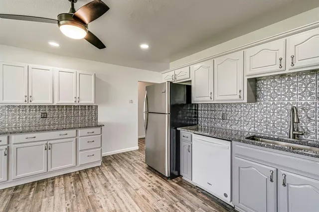 a kitchen with stainless steel appliances granite countertop a sink and cabinets