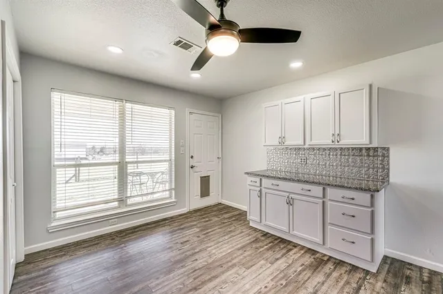 a kitchen with granite countertop a stove and a wooden floors
