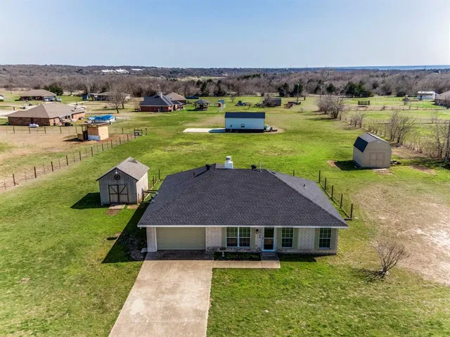 a aerial view of a house with swimming pool and a yard
