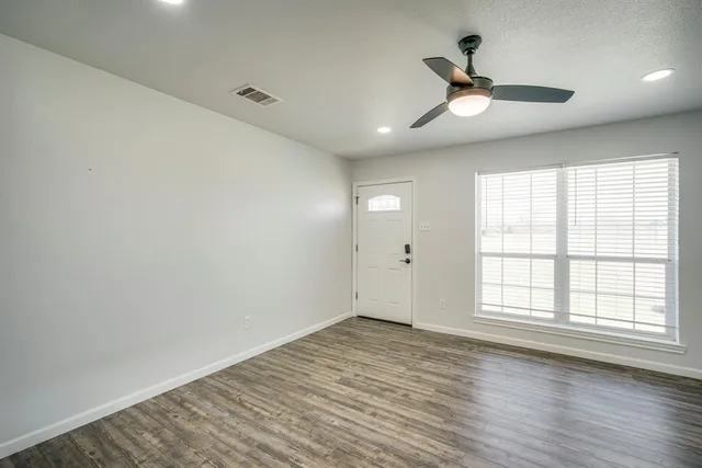 wooden floor in an empty room with a window