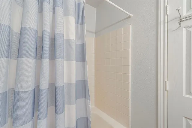 a bathroom with a shower curtain and a shower curtain
