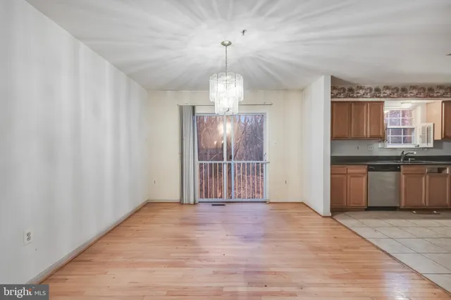 a view of a kitchen with granite countertop a sink and dishwasher with wooden floor