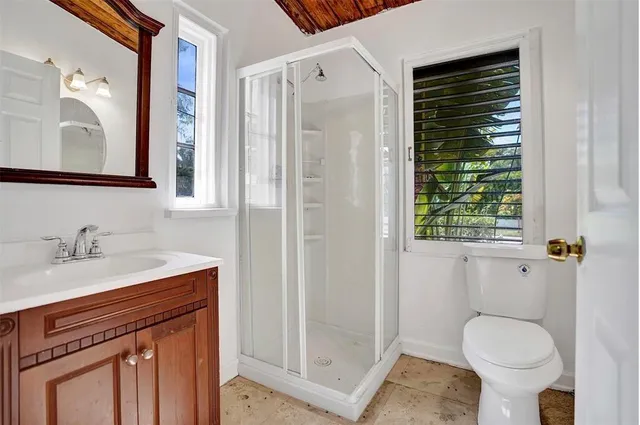 a bathroom with a granite countertop sink toilet and shower