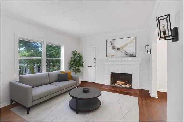 a living room with furniture a fireplace and a large window