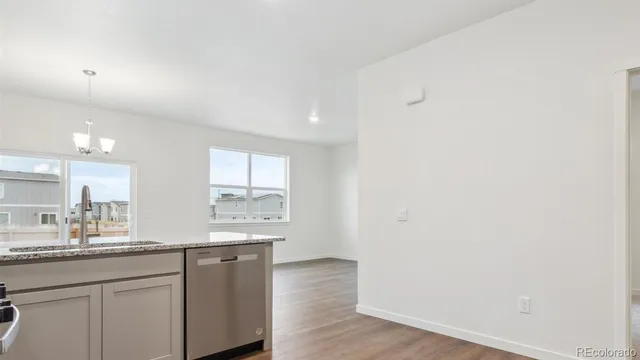 a large kitchen with a sink and wooden floor