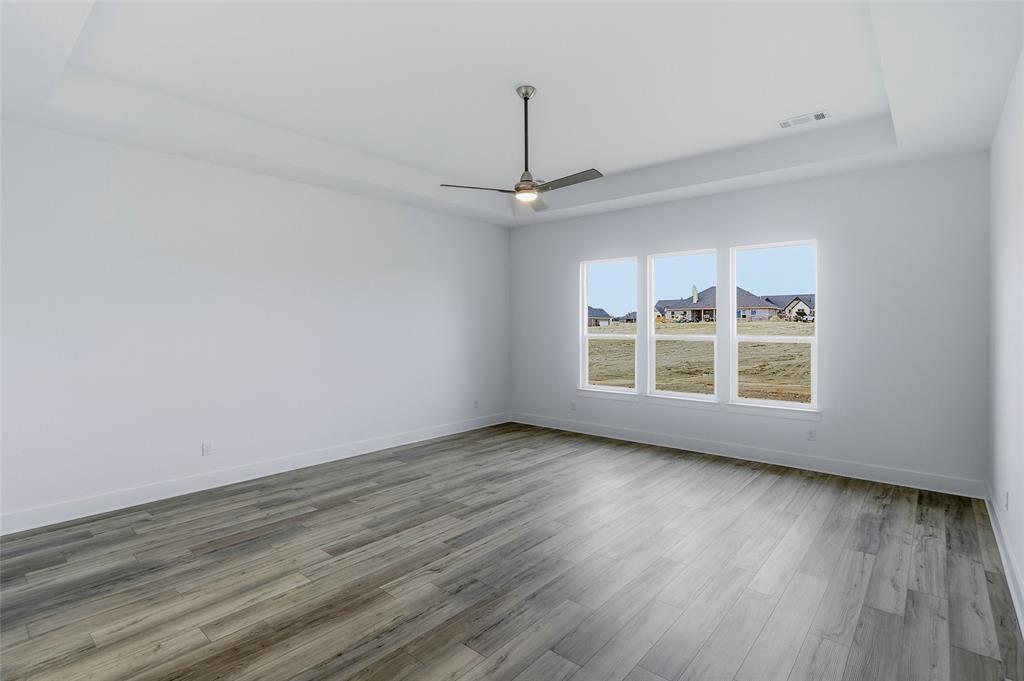 808 Vly Rdg Road Van Alstyne, TX 75495 - Photo 21 of 39 a view of an empty room with wooden floor fridge and a window