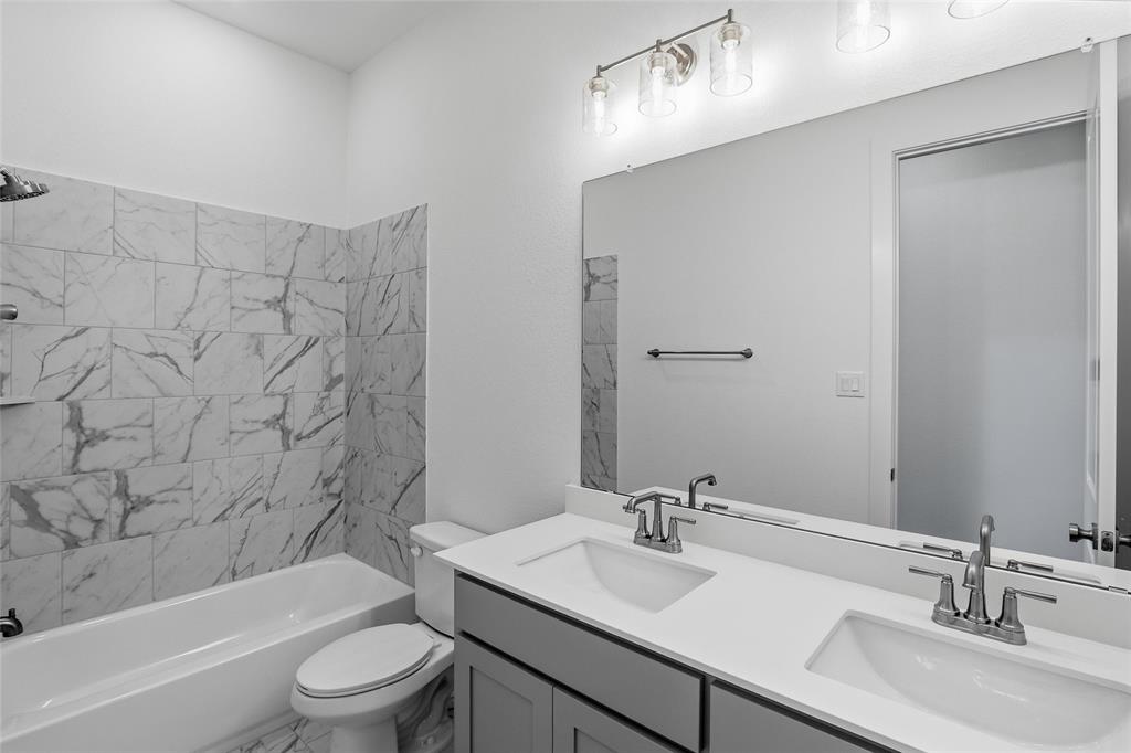 808 Vly Rdg Road Van Alstyne, TX 75495 - Photo 32 of 39 a bathroom with a bathtub shower sink vanity mirror and toilet