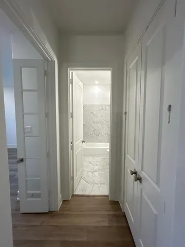 a view of a hallway with wooden floor