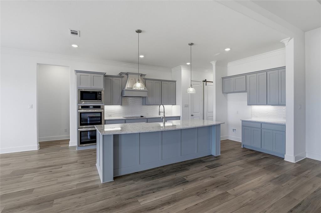 808 Vly Rdg Road Van Alstyne, TX 75495 - Photo 5 of 39 a large kitchen with stainless steel appliances a large counter top a sink a stove and a refrigerator
