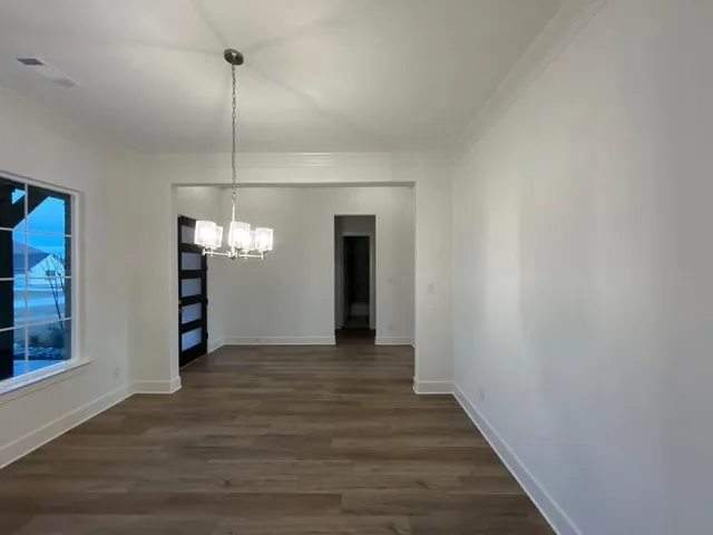a view of a room with wooden floor staircase and a kitchen