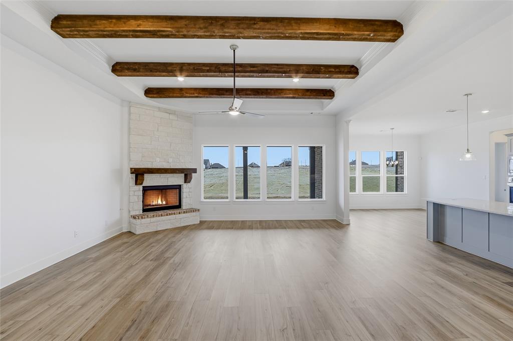 808 Vly Rdg Road Van Alstyne, TX 75495 - Photo 8 of 39 an empty room with wooden floor a fireplace and windows
