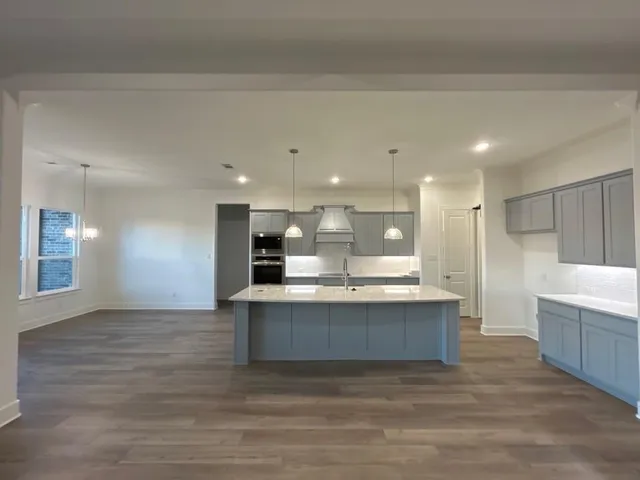 a view of kitchen with kitchen island wooden floor and center island