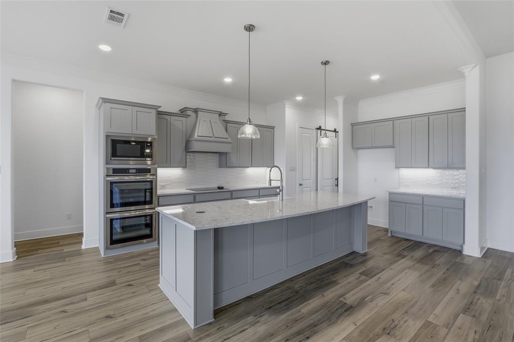 808 Vly Rdg Road Van Alstyne, TX 75495 - Photo 10 of 39 a large kitchen with stainless steel appliances a large counter top a stove and a refrigerator