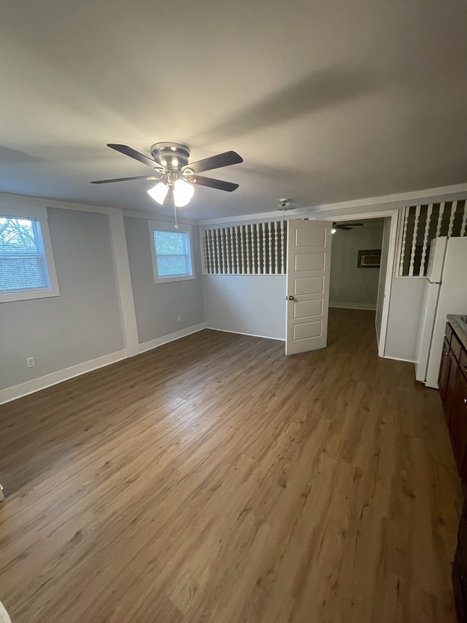 1021 West College Street, Unit B Murfreesboro, TN 37129 - Photo 1 of 5 an empty room with wooden floor fan and windows