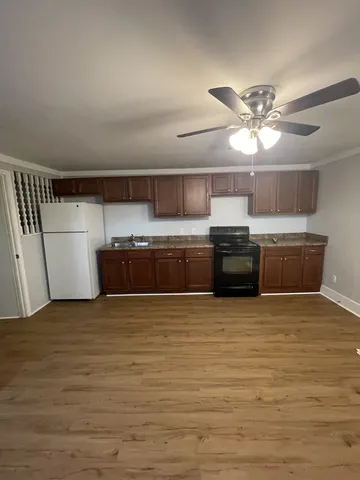 a view of kitchen with stainless steel appliances granite countertop a stove and a sink