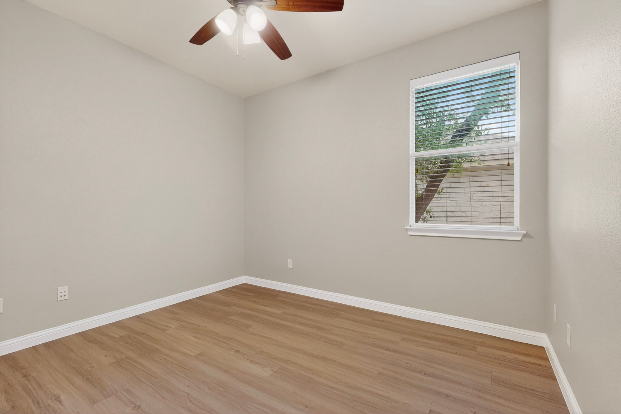 178 Limestone Trail Austin, TX 78737 - Photo 25 of 40 Room featuring wood-finish flooring, a ceiling fan with integrated lighting, and a window with horizontal blinds and white trim