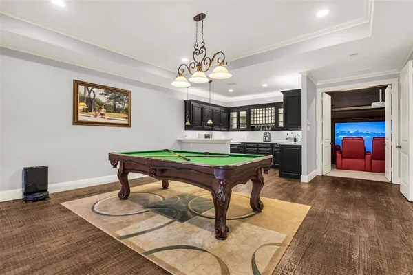 a large white bathroom with a granite countertop double vanity sink a mirror and a shower