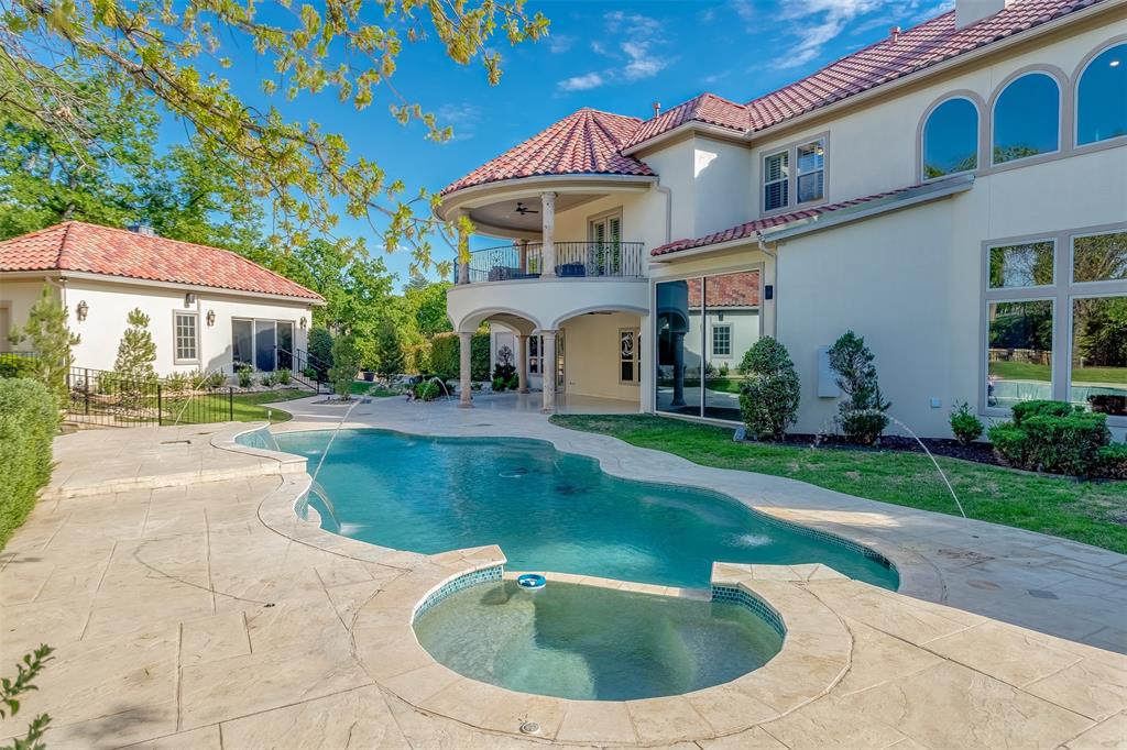 8600 Riviera Court Flower Mound, TX 75022 - Photo 32 of 40 a view of a white house with a yard plants and a fountain