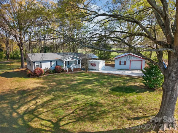 a view of a yard with a house and a tree