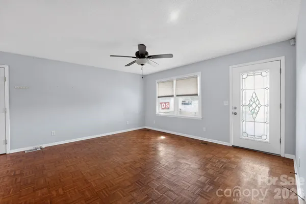 an empty room with a window and a ceiling fan