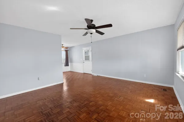 an empty room with a window and a ceiling fan