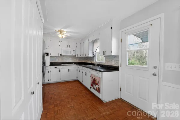 a kitchen with granite countertop a refrigerator stove and sink