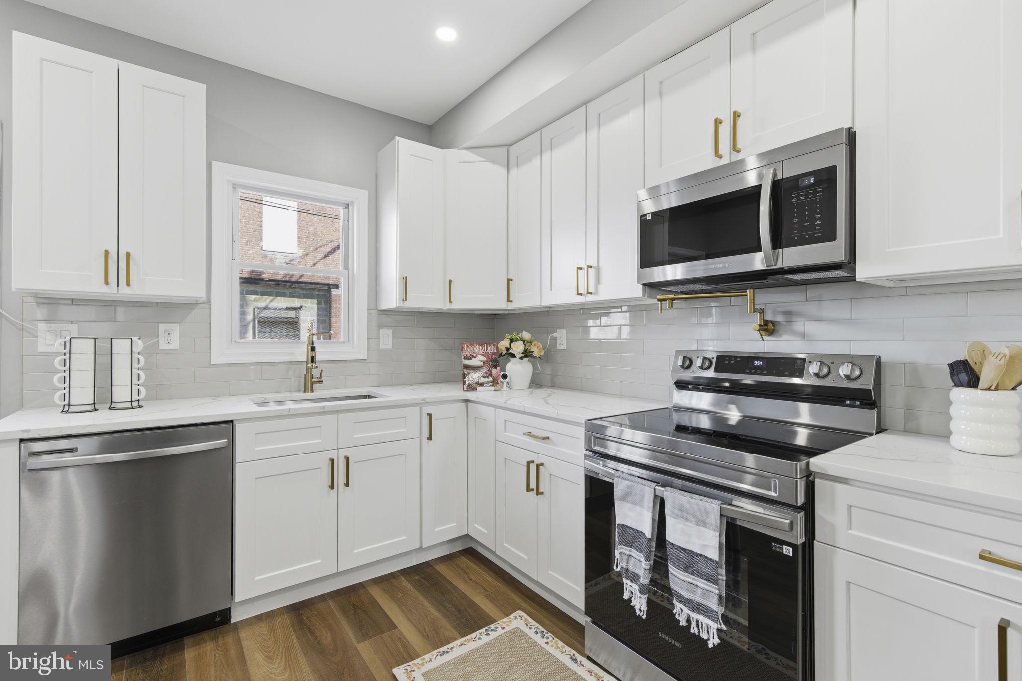 1600 Federal Street Baltimore, MD 21213 - Photo 6 of 31 a kitchen with stainless steel appliances granite countertop a stove a sink and a microwave