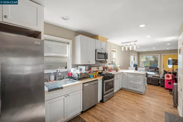 a kitchen that has a lot of cabinets in it and wooden floors