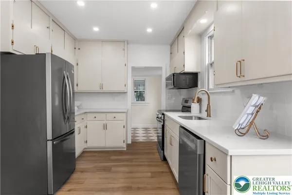 a kitchen with stainless steel appliances a refrigerator sink and microwave