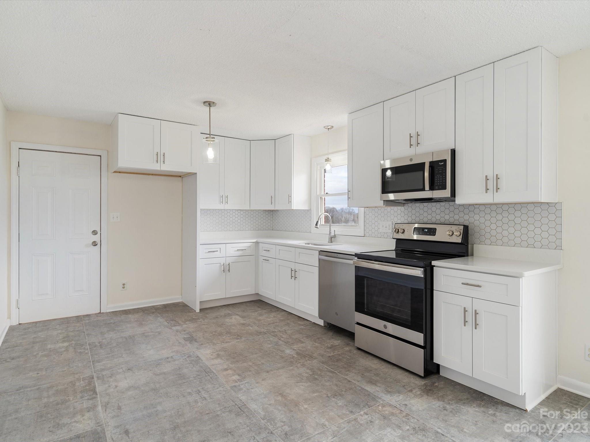 158 Baxter Road Cherryville, NC 28021 - Photo 7 of 38 a kitchen with granite countertop white cabinets and stainless steel appliances