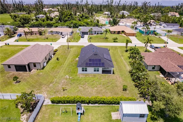 an aerial view of residential houses with outdoor space and swimming pool