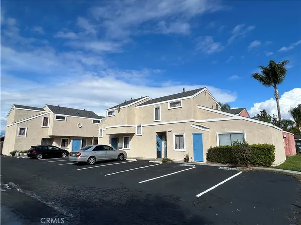 a front view of a house with cars parked on road