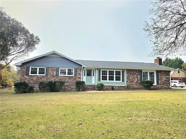 a front view of house with yard and trees around