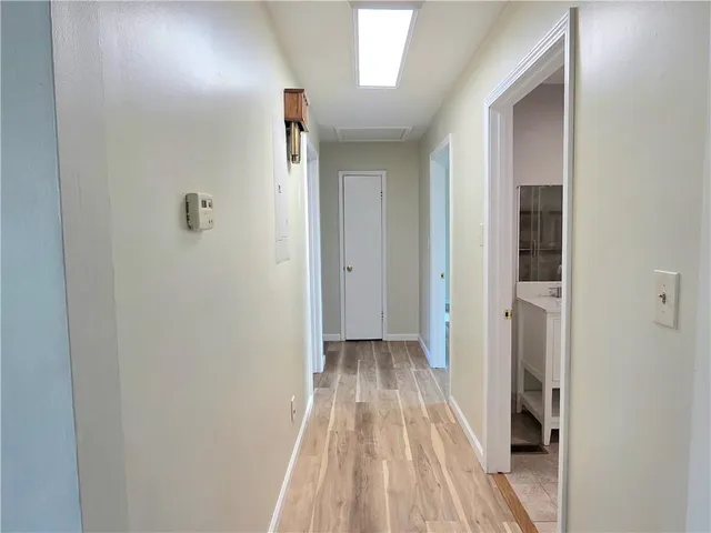 a view of a hallway with wooden floor and entryway
